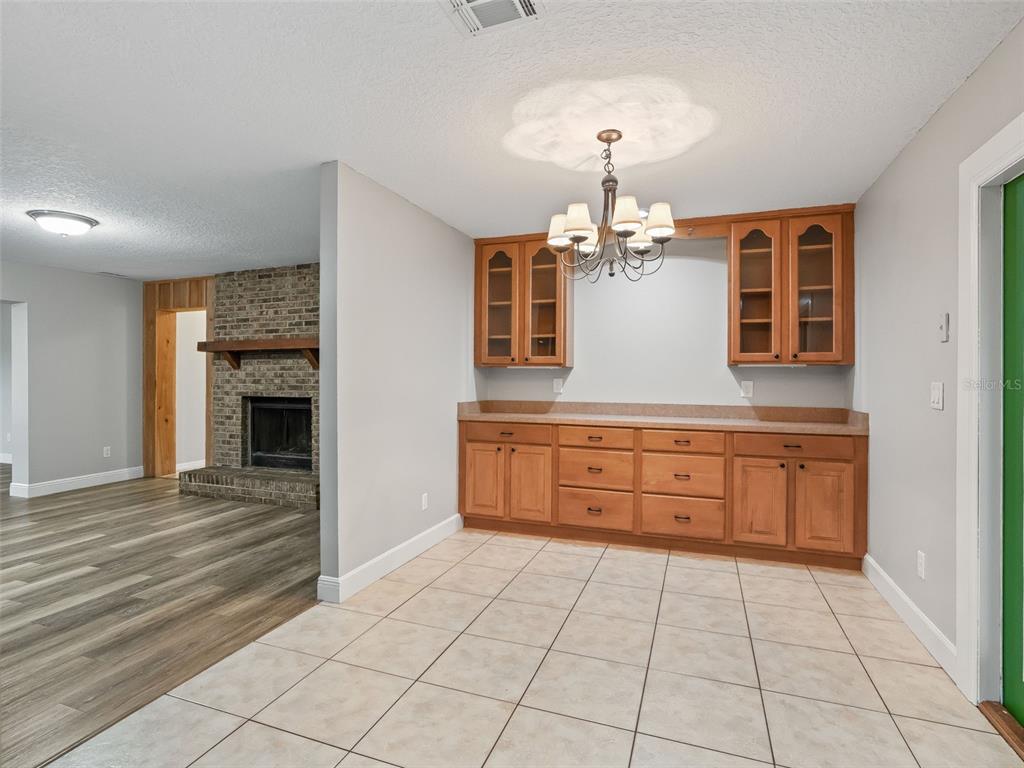 A kitchen features wood cabinets, stainless steel appliances, and light-colored laminate countertops — 8234 S US 301, BUSHNELL, FL