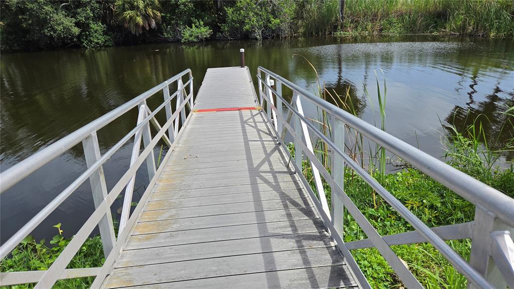 A metal dock with railings extends over a calm body of water — 1162 SE 40TH AVENUE, OKEECHOBEE, FL