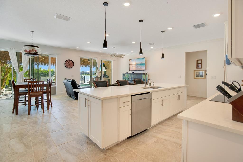 A white kitchen island with a stainless steel dishwasher sits in an open-concept living space — 260 JACKSON LOOP, DELAND, FL