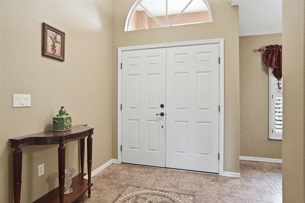 An entryway features a double front door, a console table, and tile flooring — 4159 ST IVES BOULEVARD, SPRING HILL, FL
