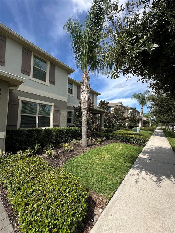 A two-story residential building with light-colored siding, brown shutters, and a palm tree in front — 16237 QUIET VISTA DRIVE, WINTER GARDEN, FL