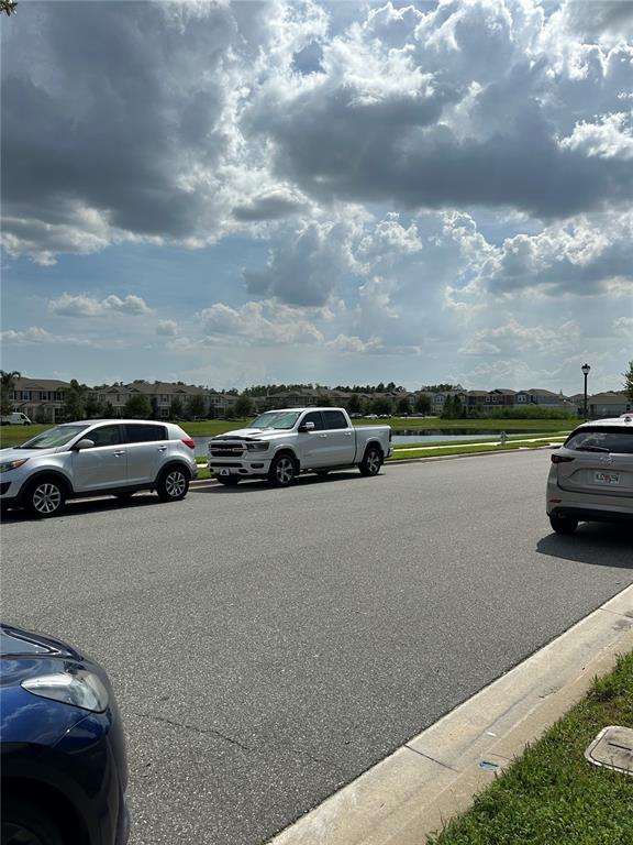 A street view shows parked cars along a road with houses and a pond nearby — 16237 QUIET VISTA DRIVE, WINTER GARDEN, FL