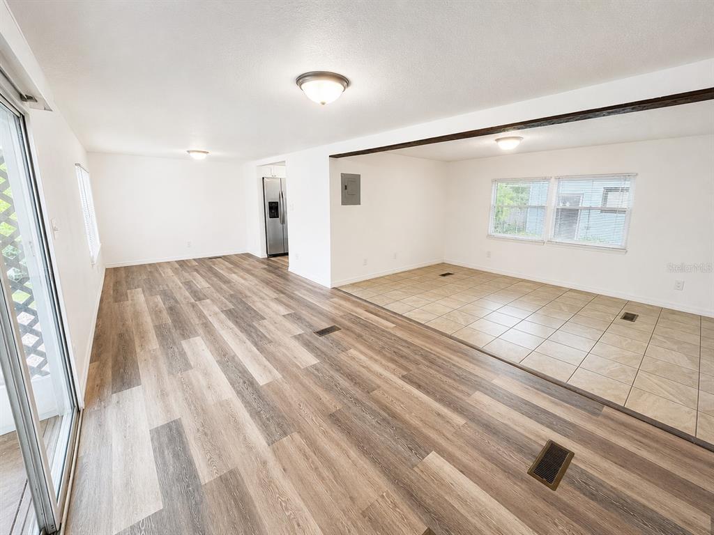 An open-concept living area features wood-look vinyl flooring, a tiled section, and recessed lighting — 1052 OSCEOLA TRAIL, CASSELBERRY, FL