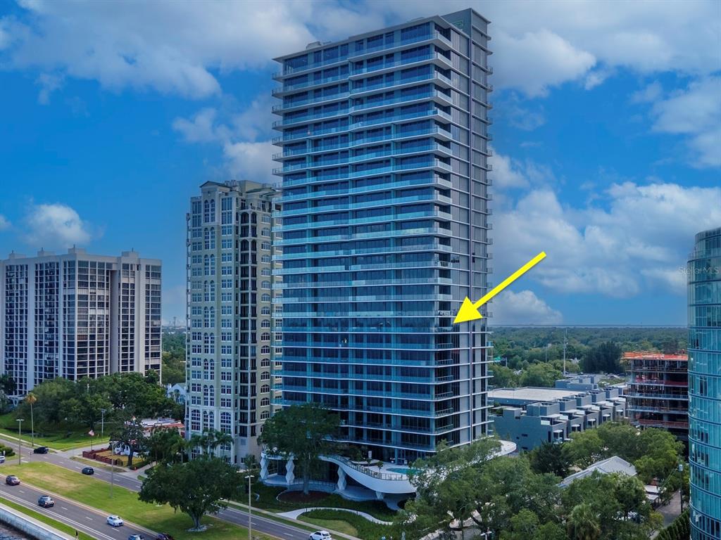 An aerial view of a modern glass high-rise building with a yellow arrow pointing outward — 3101 BAYSHORE BOULEVARD UNIT 1001, TAMPA, FL