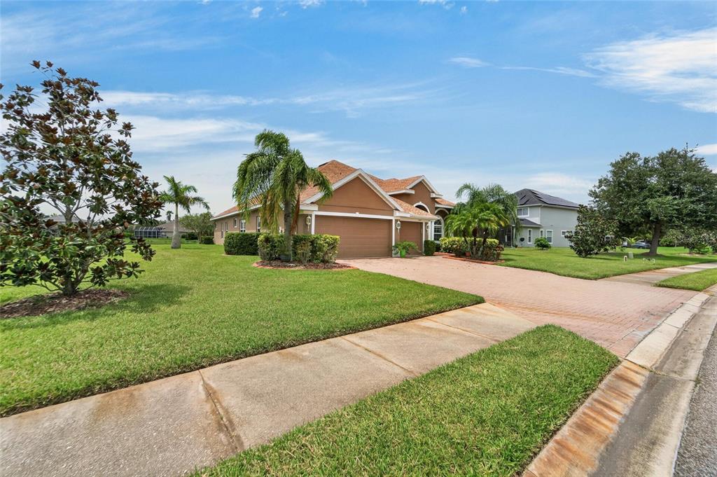 A single-story house with a brown exterior, a brick driveway, and a manicured lawn — 4315 70TH AVENUE E, ELLENTON, FL