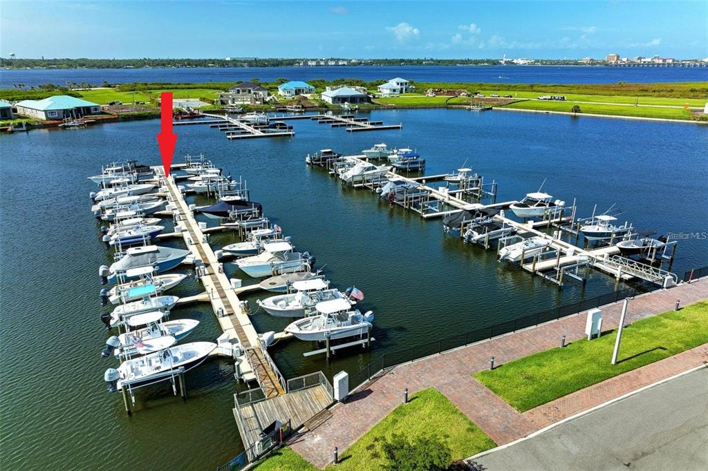 An aerial view shows a marina with numerous boats docked in slips along wooden piers — 1802 5TH STREET E, PALMETTO, FL