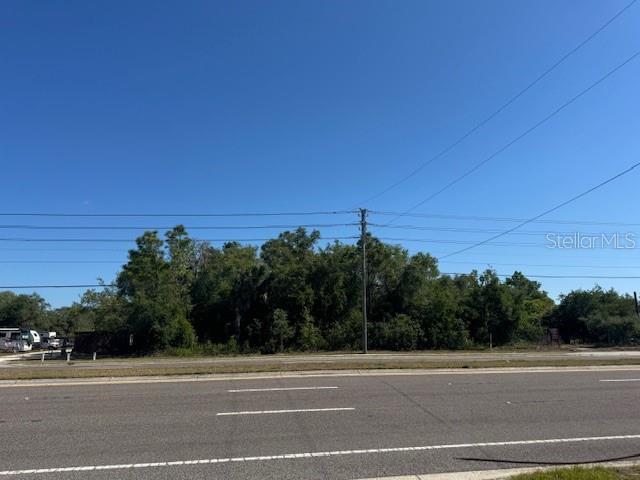A view of a vacant, wooded lot situated along a paved road — 10331 STATE ROAD 52, HUDSON, FL