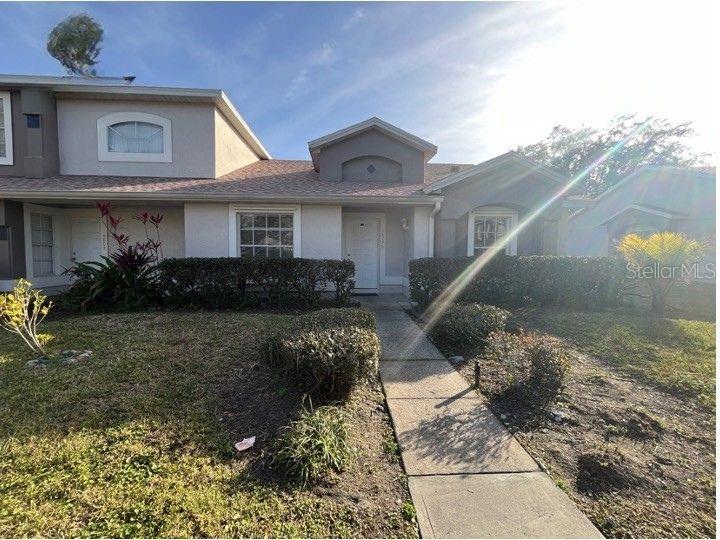A single-story residential building with a concrete walkway leading to a central front entrance — 14796 LAGUNA BEACH CIRCLE, ORLANDO, FL
