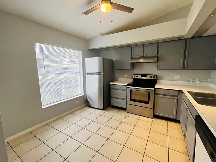 A kitchen with gray cabinets, stainless steel appliances, white countertops, and light-colored tile flooring — 14796 LAGUNA BEACH CIRCLE, ORLANDO, FL