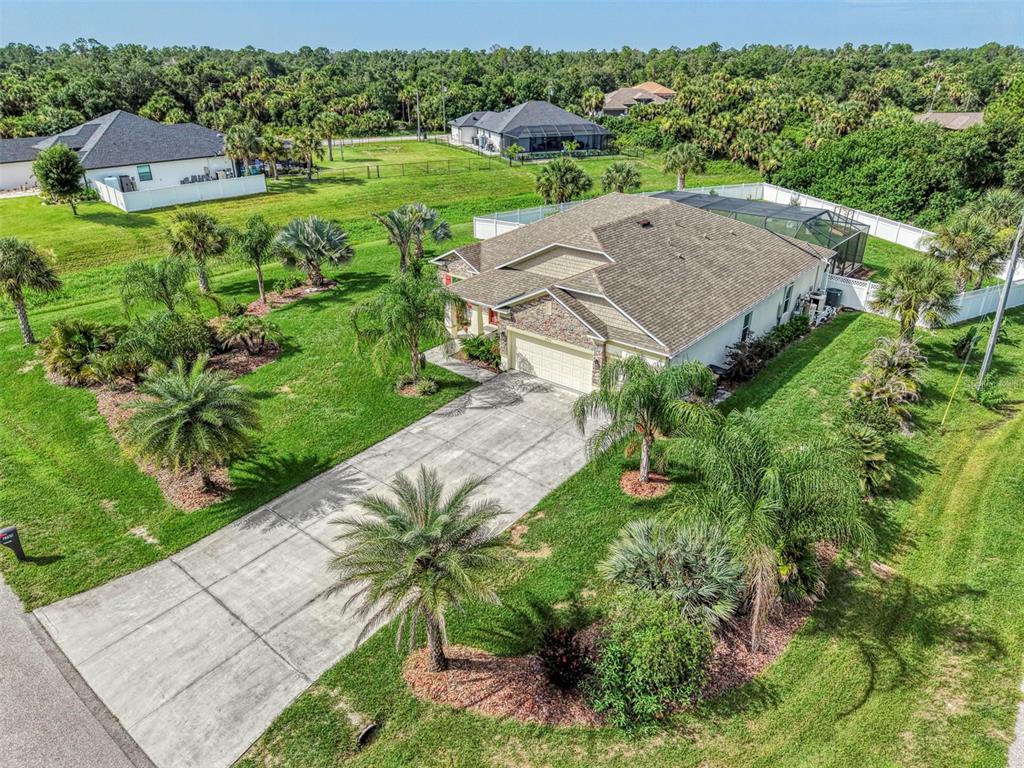 An aerial view shows a single-story house with a concrete driveway and a screened pool — 2705 LAMKIN ROAD, NORTH PORT, FL