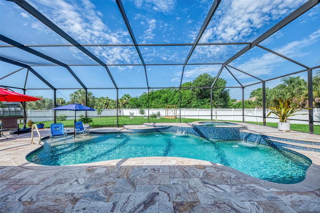 A screened-in swimming pool and spa with stone decking and a large backyard — 2705 LAMKIN ROAD, NORTH PORT, FL