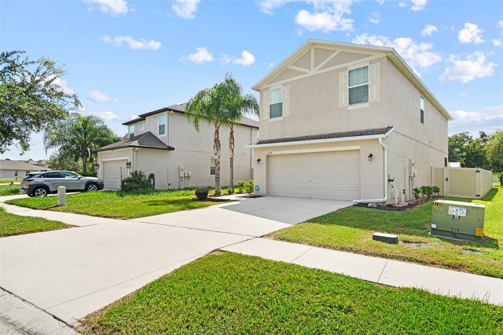A two-story suburban house with a beige stucco exterior and a two-car garage — 13728 REINDEER CIRCLE, HUDSON, FL