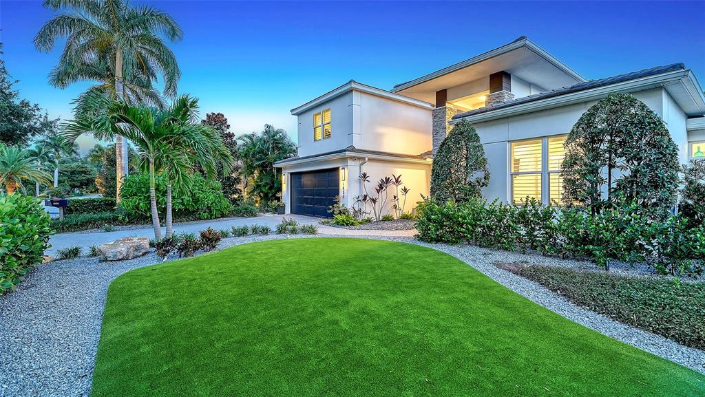 A modern two-story house features a manicured green lawn, palm trees, and gravel landscaping — 1838 OLEANDER STREET, SARASOTA, FL