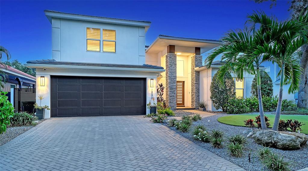 A modern two-story house with a dark garage door and stone accents on the exterior — 1838 OLEANDER STREET, SARASOTA, FL