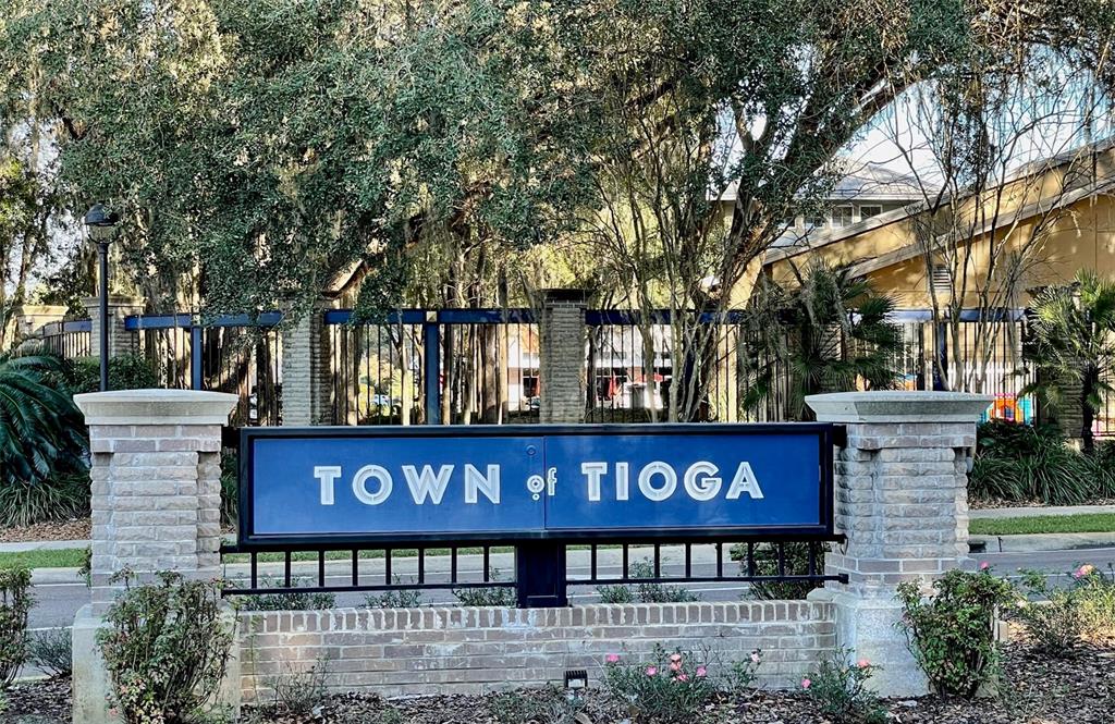A blue sign reading Town of Tioga stands between two brick pillars under large trees — 13327 SW 9TH ROAD, NEWBERRY, FL