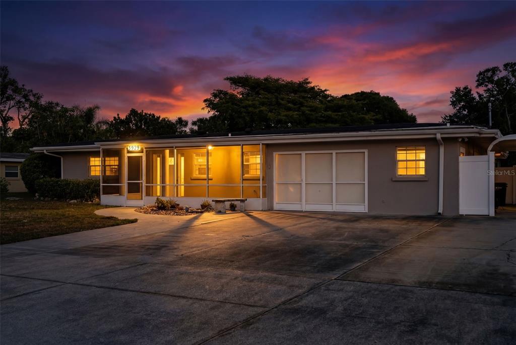 A single-story house with a screened-in porch and a concrete driveway under a blue sky — 5929 MURDOCK AVENUE, SARASOTA, FL