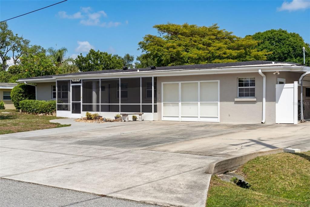 A single-story house with a screened front porch, a two-car garage, and a carport — 5929 MURDOCK AVENUE, SARASOTA, FL