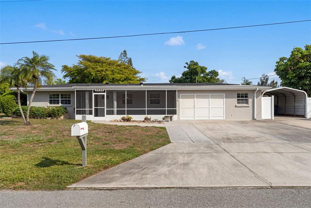 A single-story house with a screened-in front porch and two palm trees in the yard — 5929 MURDOCK AVENUE, SARASOTA, FL