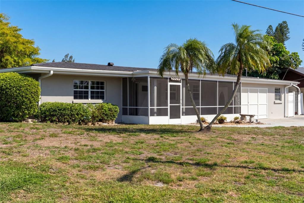 A single-story house features a screened-in front porch and a concrete walkway — 5929 MURDOCK AVENUE, SARASOTA, FL