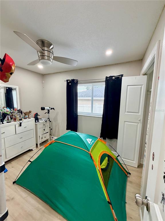A bedroom features a green tent, a white dresser, a ceiling fan, and black curtains — 3620 N 56TH STREET, TAMPA, FL