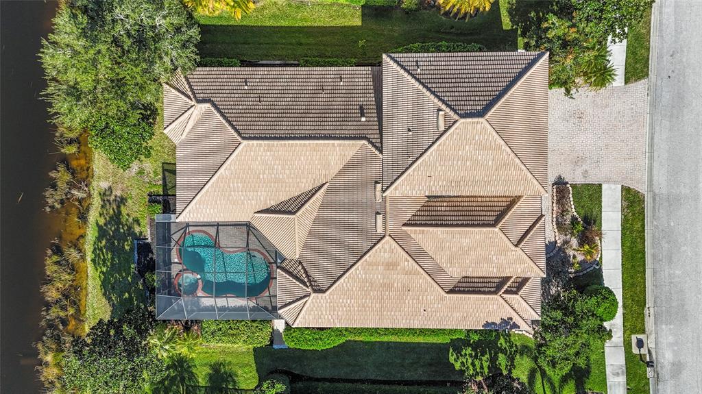 An aerial view of a house with a tiled roof, a screened pool, and landscaping — 6961 SCRUB JAY DRIVE, SARASOTA, FL