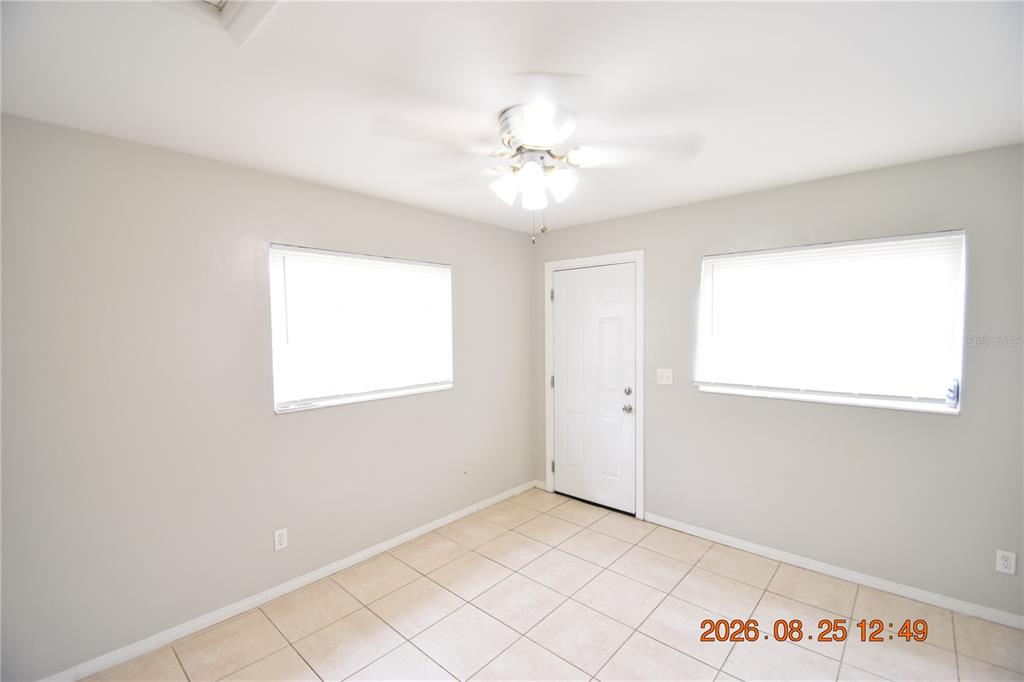 A room with light-colored walls, tiled flooring, a ceiling fan, and two windows — 5124 18TH AVENUE N, ST PETERSBURG, FL