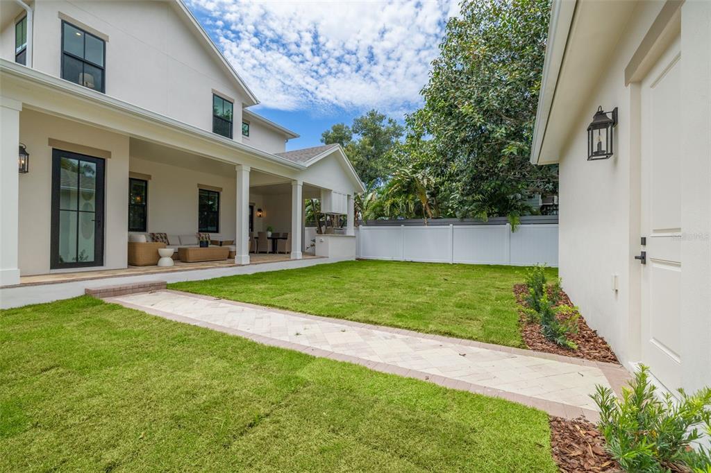 A backyard features a covered patio, a paved walkway, and a white vinyl privacy fence — 1037 26TH AVENUE N, ST PETERSBURG, FL