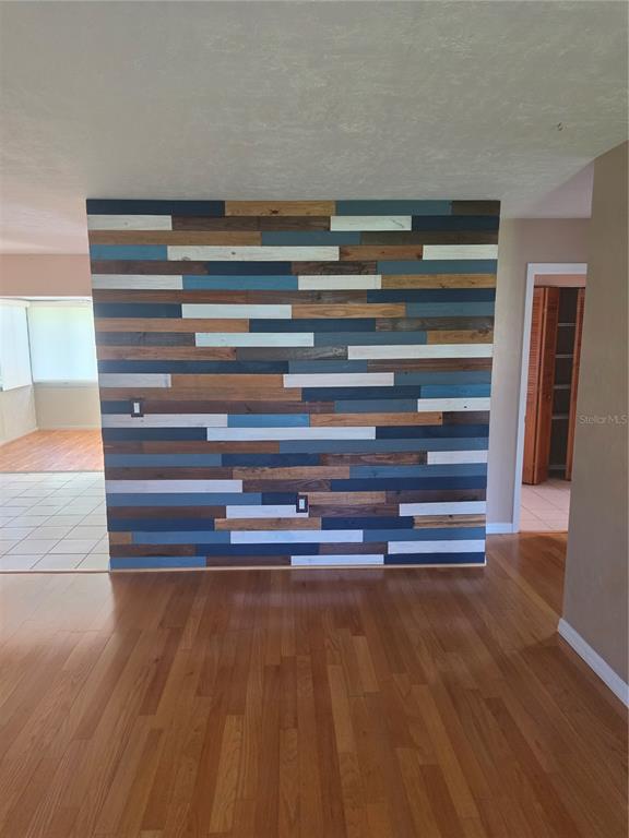 A room features a prominent accent wall covered in horizontal planks of varying wood tones — 7315 SE 109TH PLACE, BELLEVIEW, FL