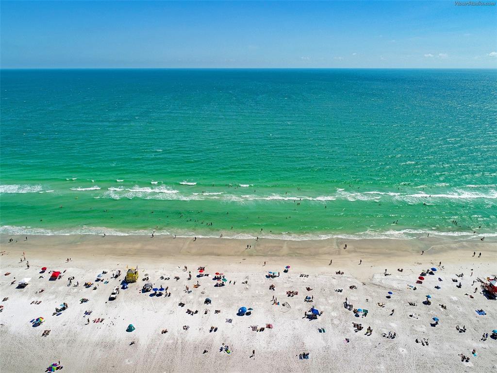 An aerial view of a crowded sandy beach with turquoise ocean water and blue skies — 5640 CAPE LEYTE DRIVE, SARASOTA, FL