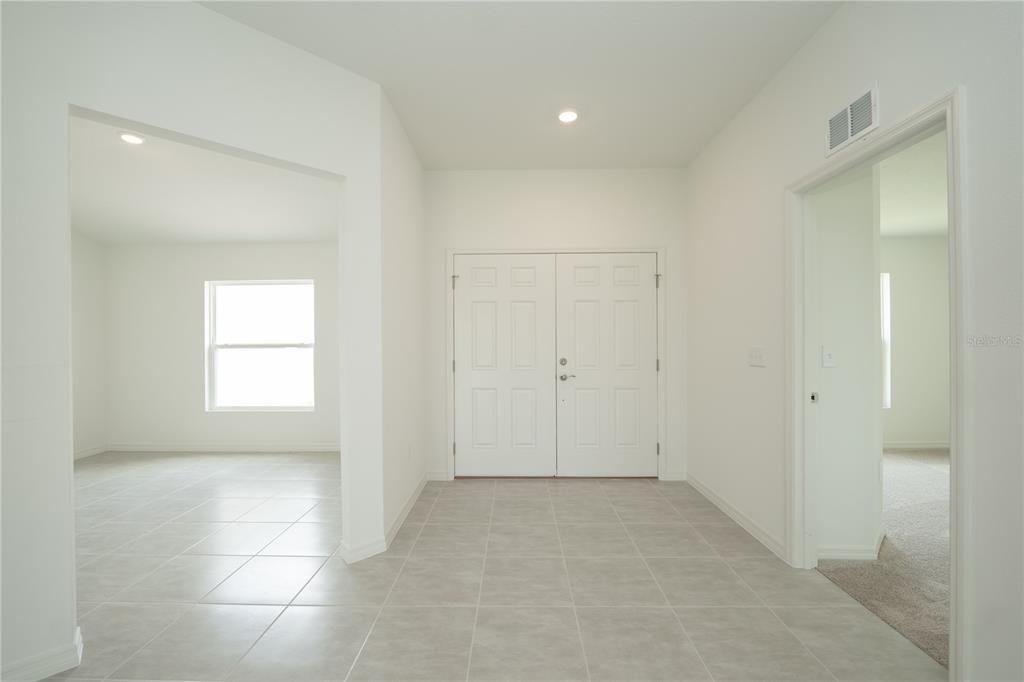 An entryway with light tile flooring, white walls, and double doors leading to the outside — 3432 BLUEBERRY TRAIL, BARTOW, FL