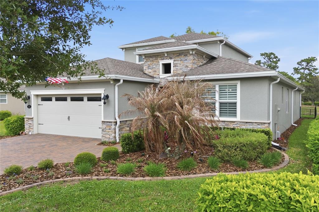A two-story house with a stone-accented facade, a two-car garage, and landscaped front yard — 261 OLD MOSS CIRCLE, DELAND, FL