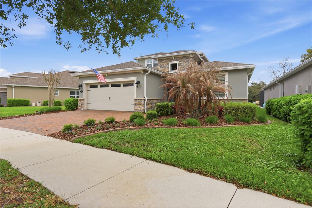 A two-story house with a stone facade, a two-car garage, and a landscaped front yard — 261 OLD MOSS CIRCLE, DELAND, FL