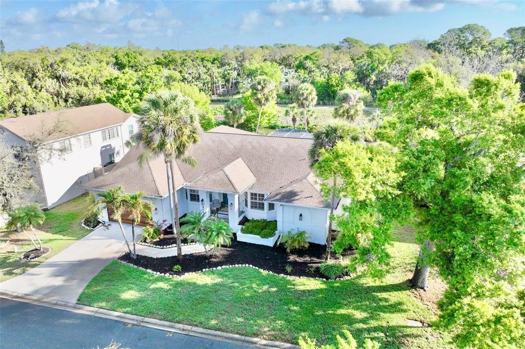 An aerial view of a single-story house with a brown roof and surrounding palm trees — 4717 E TRAILS DRIVE, SARASOTA, FL