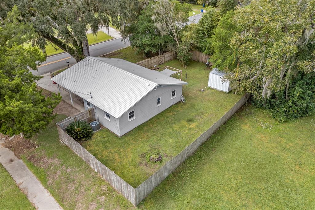 An aerial view of a gray house with a metal roof and a fenced yard — 14004 NW 158TH AVENUE, ALACHUA, FL