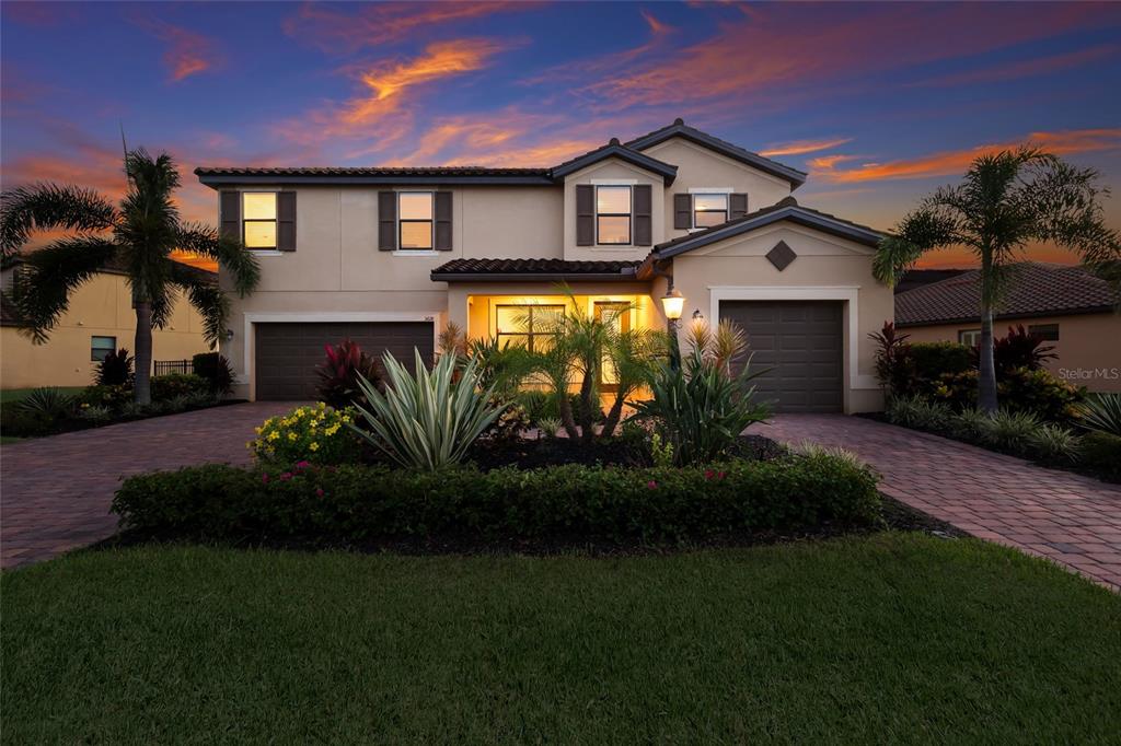 A two-story suburban house with a three-car garage and landscaped front yard at sunset — 3618 SCRUB CREEK RUN, LAKEWOOD RANCH, FL