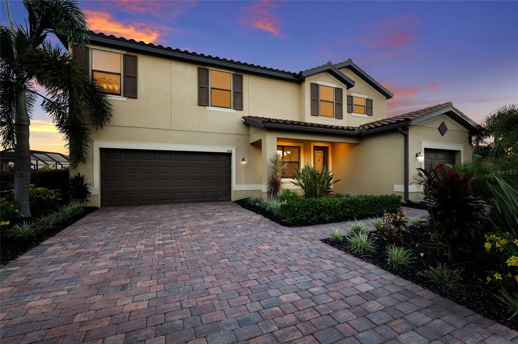 A two-story house with a paved driveway, a three-car garage, and a landscaped front yard — 3618 SCRUB CREEK RUN, LAKEWOOD RANCH, FL