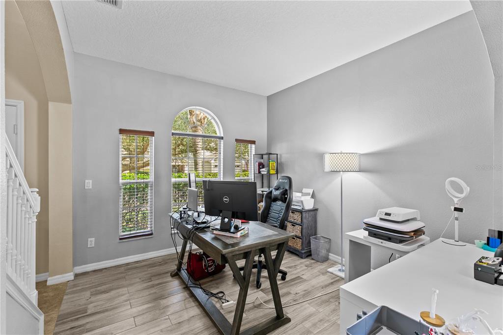 A home office features a wooden desk, a gaming chair, and a white printer table — 11714 GREAT COMMISSION WAY, ORLANDO, FL