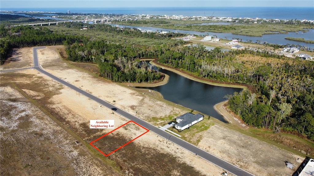 An aerial view shows a vacant residential lot outlined in red next to a paved road — 197 STILLWATER DRIVE, FLAGLER BEACH, FL