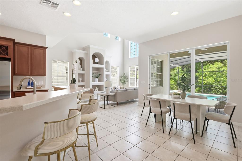 A dining room with a dark table, cream chairs, a crystal chandelier, and a staircase — 2555 SAND ARBOR CIRCLE, ORLANDO, FL