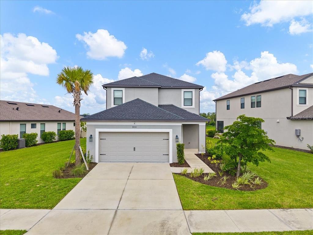 An aerial view shows suburban houses with driveways and lawns bordering a small pond — 9016 TEQUILA SUNRISE DRIVE, SARASOTA, FL