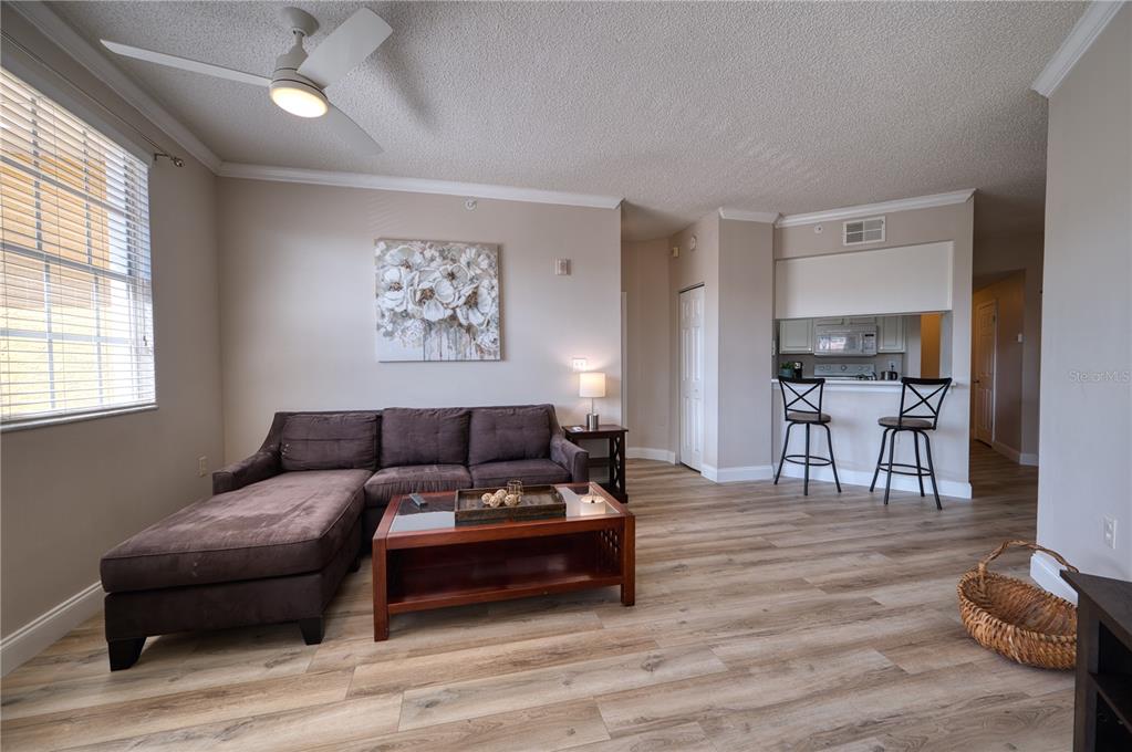 An exterior view of a multi-story yellow apartment building with a parking lot — 5551 BENTGRASS DRIVE UNIT 11-303, SARASOTA, FL