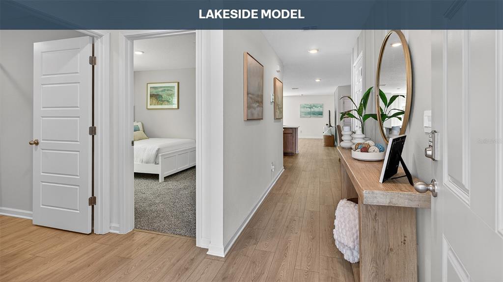 A hallway with wood-look flooring leads past a bedroom to an open living area — 18 SAWDUST LANE, PALM COAST, FL