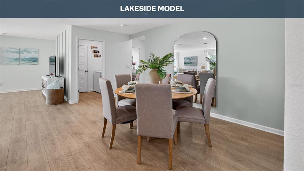 A dining area features a round wooden table with four chairs and a large mirror — 18 SAWDUST LANE, PALM COAST, FL