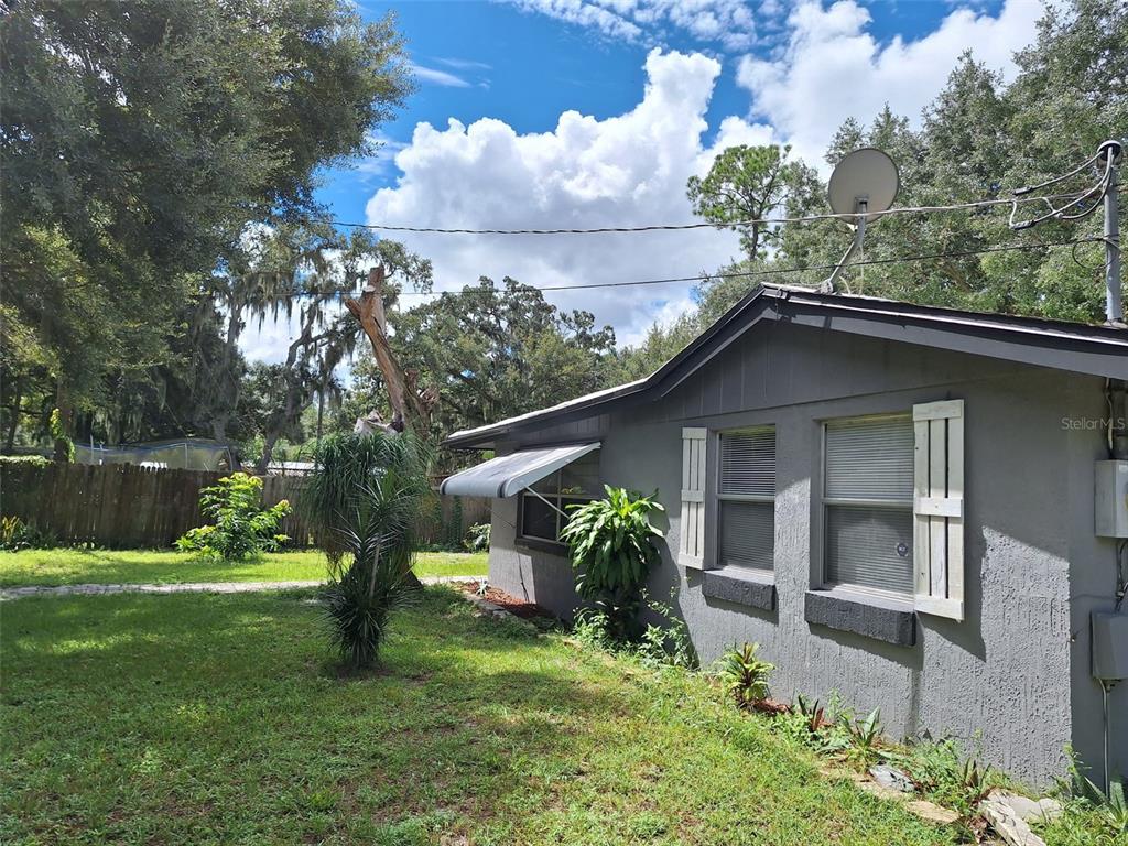 A single-story gray house with a red front door and a gravel driveway — 1257 LYNCHBURG ROAD, LAKE ALFRED, FL