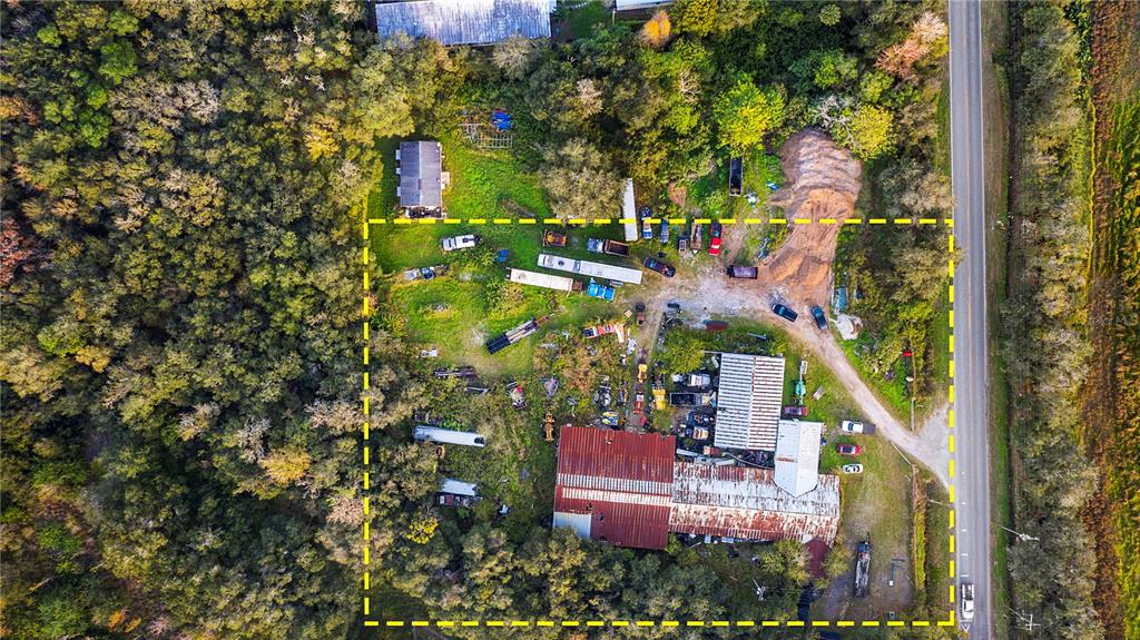 An aerial view shows a rural property with a house, a large barn, and scattered equipment — 15058 BALM ROAD, WIMAUMA, FL