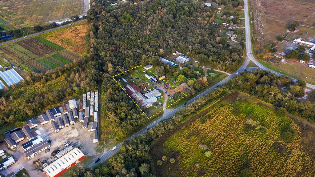 An aerial view shows a property outlined in yellow surrounded by trees and rural roads — 15058 BALM ROAD, WIMAUMA, FL