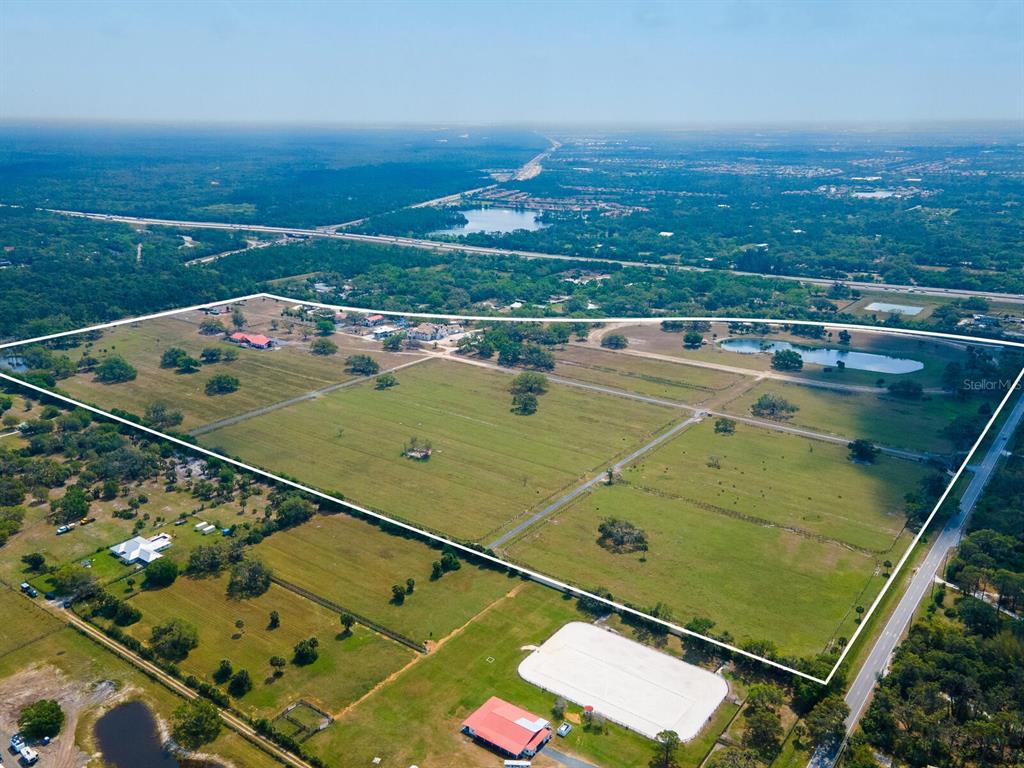 An aerial view shows a large, fenced-in rural property with pastures, ponds, and several buildings — 0396014400, VENICE, FL
