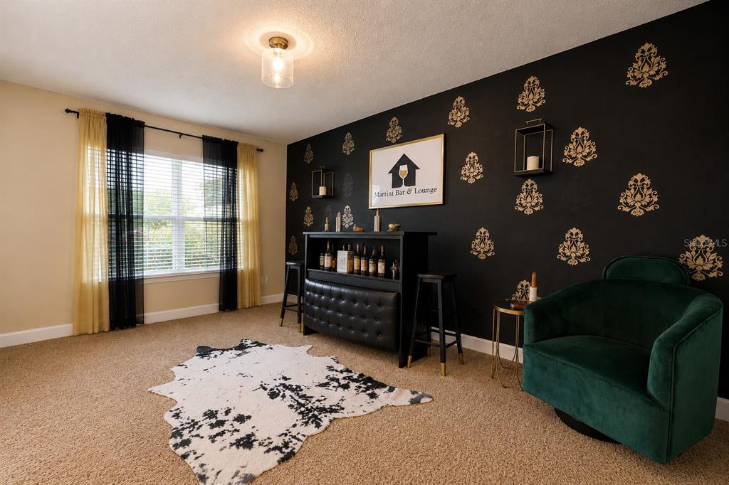 A bright entryway features a white front door, a console table, and abstract wall art — 7733 SLOEWOOD DRIVE, LEESBURG, FL