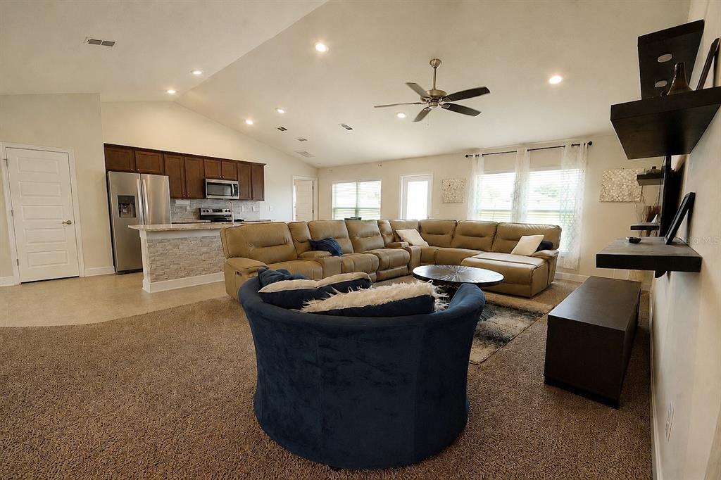 A home bar area features a black accent wall with gold stencils and a green chair — 7733 SLOEWOOD DRIVE, LEESBURG, FL