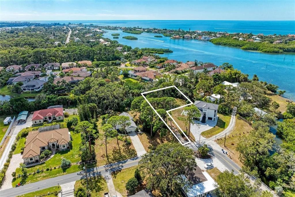 An aerial view shows a residential lot outlined in white near a coastal waterway — 0 ROBERTS RD. ROAD, NOKOMIS, FL
